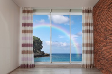 View of beautiful rainbow over sea through big windows