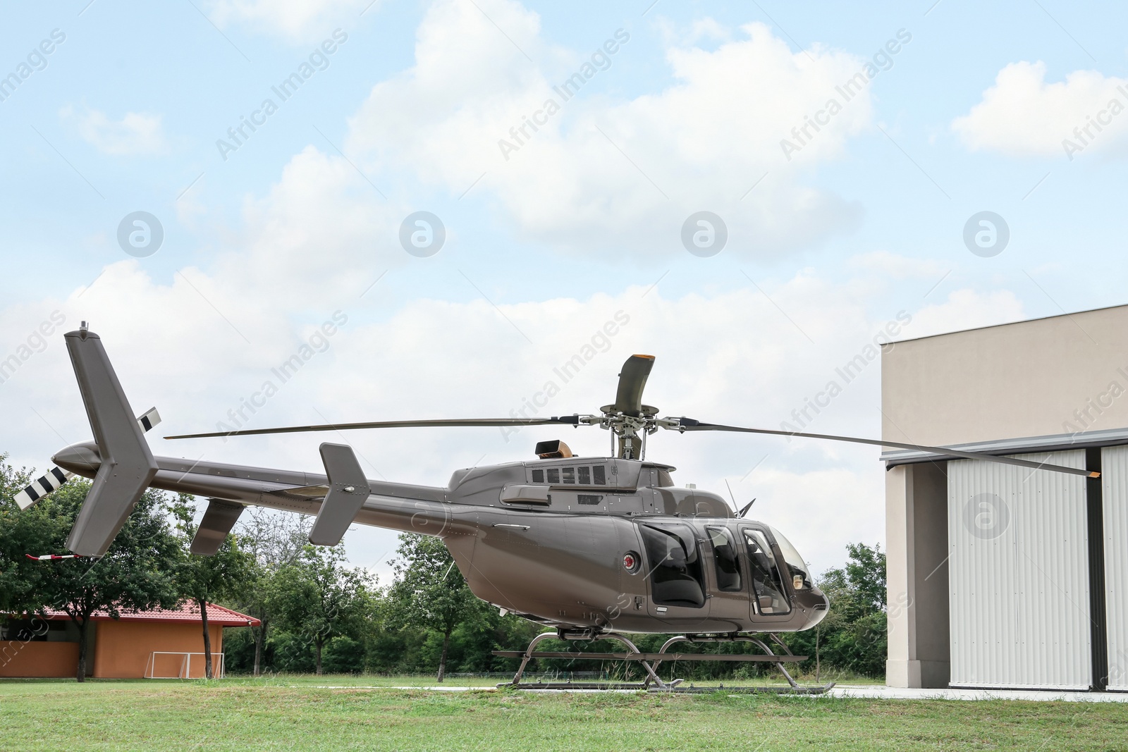 Photo of Beautiful helicopter on helipad near white hangar