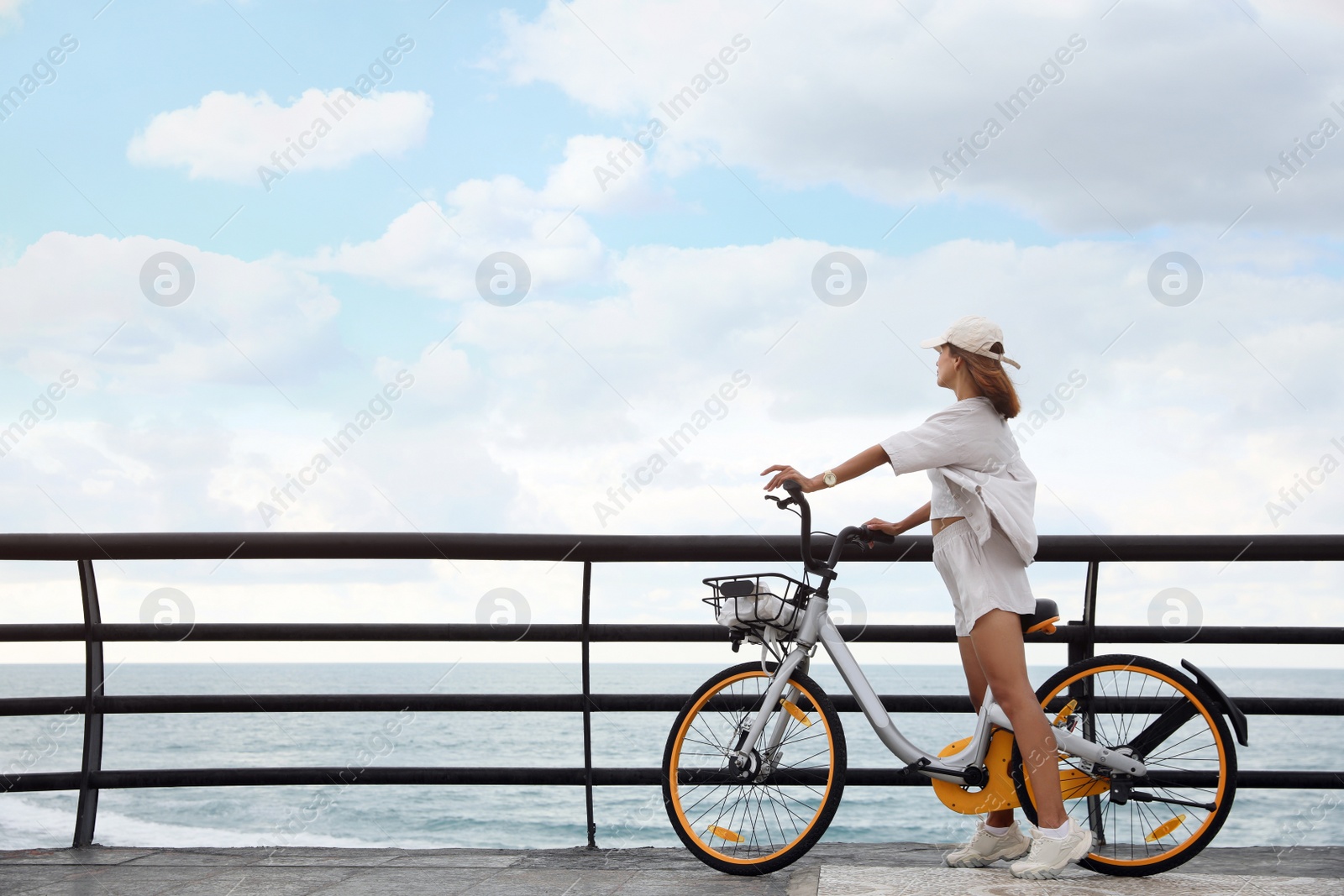 Photo of Beautiful young woman with bicycle near sea. Space for text