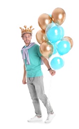 Young man with crown and air balloons on white background