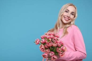 Beautiful young woman on light blue background