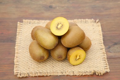 Photo of Heap of whole and cut fresh kiwis on wooden table