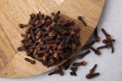 Pile of aromatic cloves on light table, top view