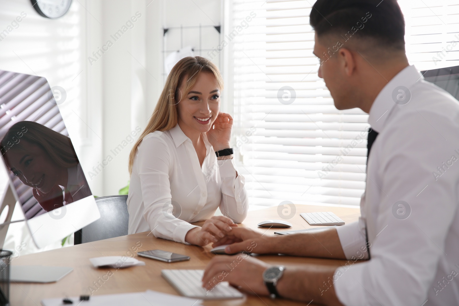 Photo of Young woman flirting with her colleague during work in office