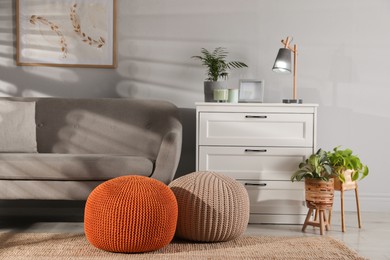 Stylish knitted poufs and sofa in living room. Home design