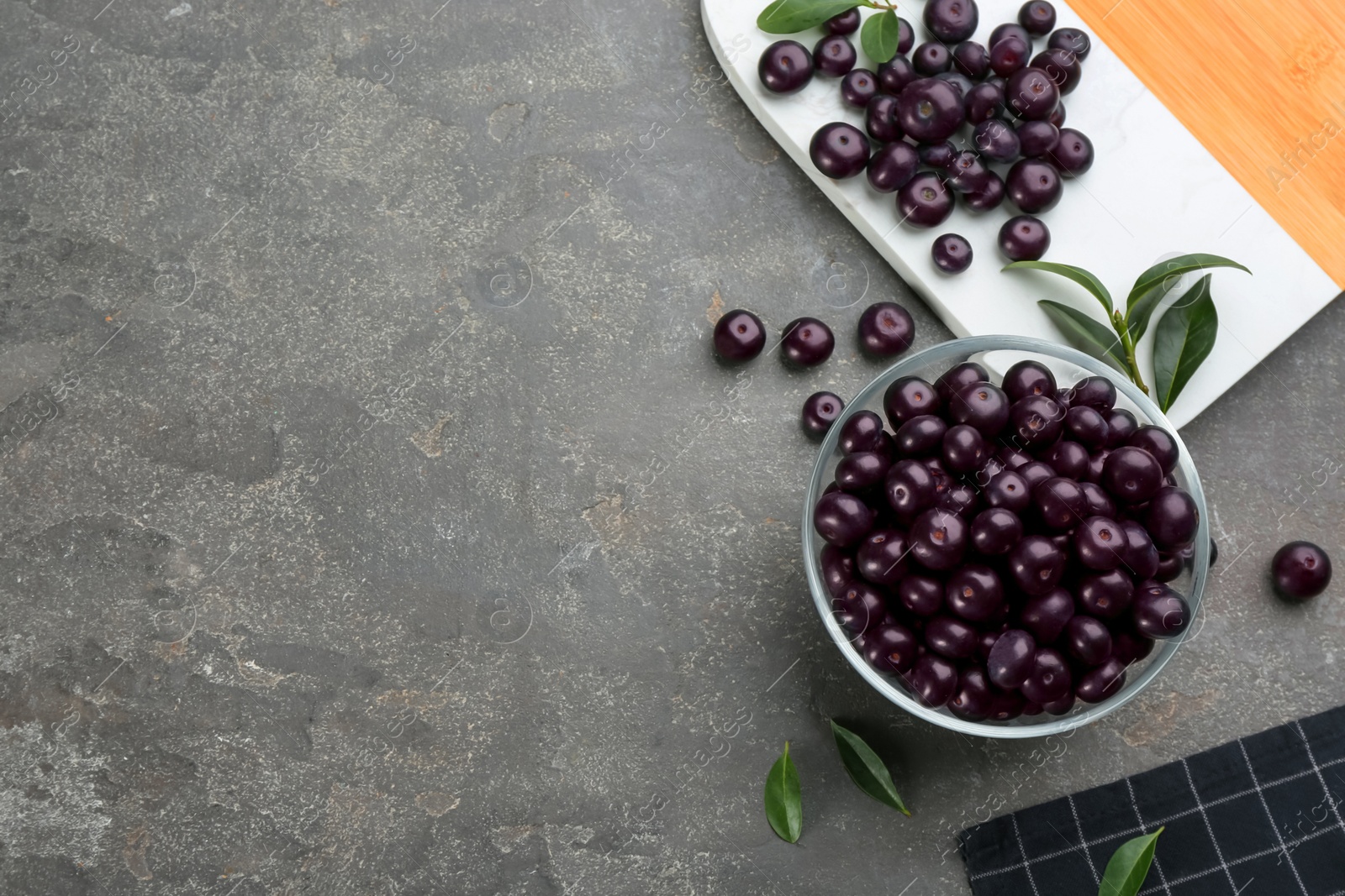 Photo of Flat lay composition with tasty acai berries on grey table. Space for text