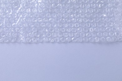 Photo of Transparent bubble wrap on gray background, top view. Space for text