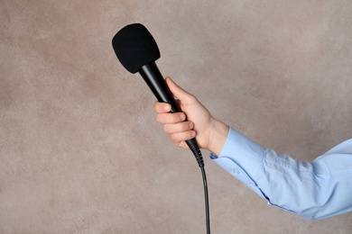 Woman holding microphone on color background, space for text