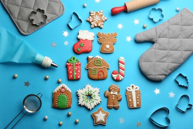 Flat lay composition with delicious gingerbread cookies and kitchen items on light blue background