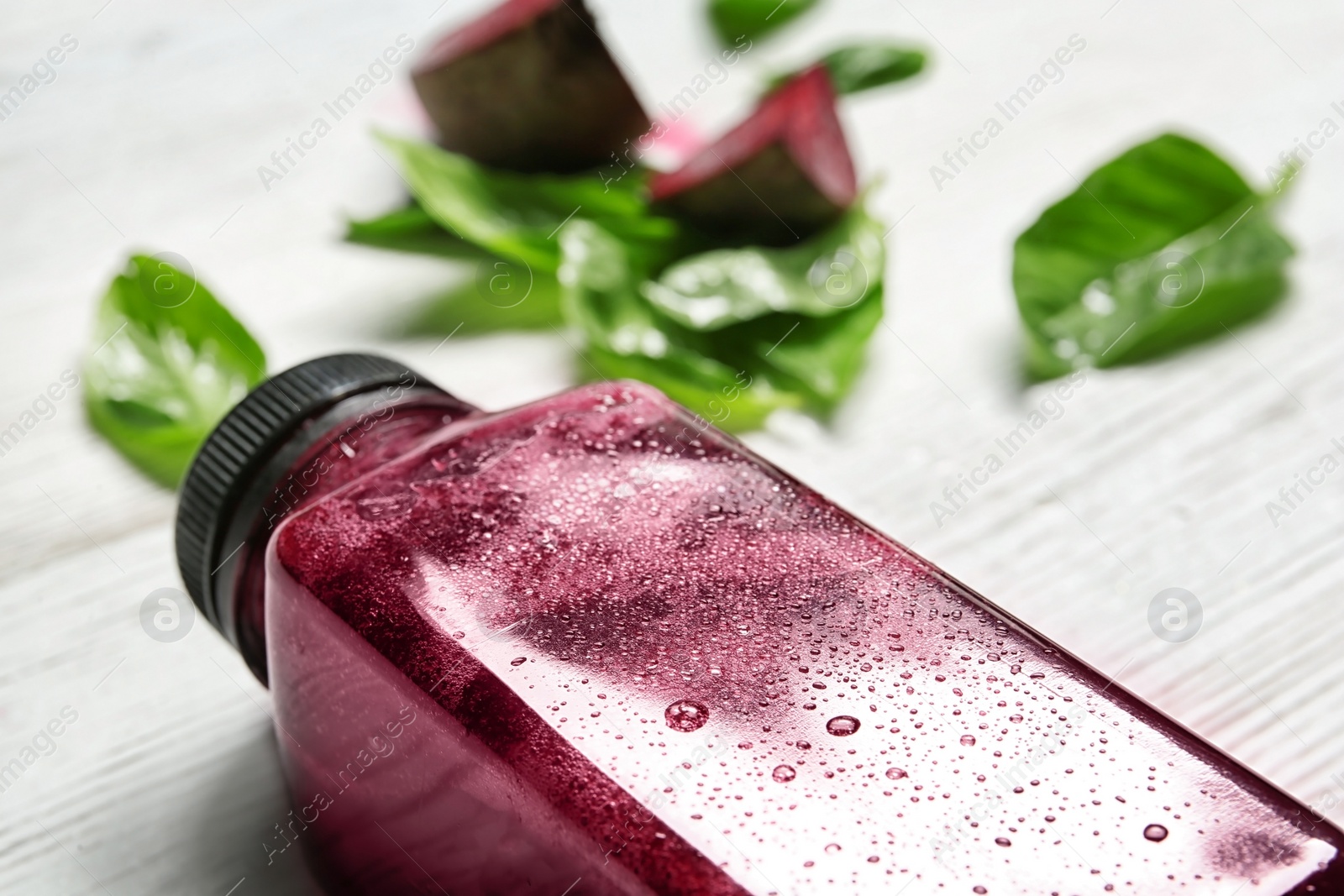 Photo of Bottle of beet smoothie on table, closeup