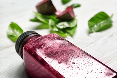 Bottle of beet smoothie on table, closeup