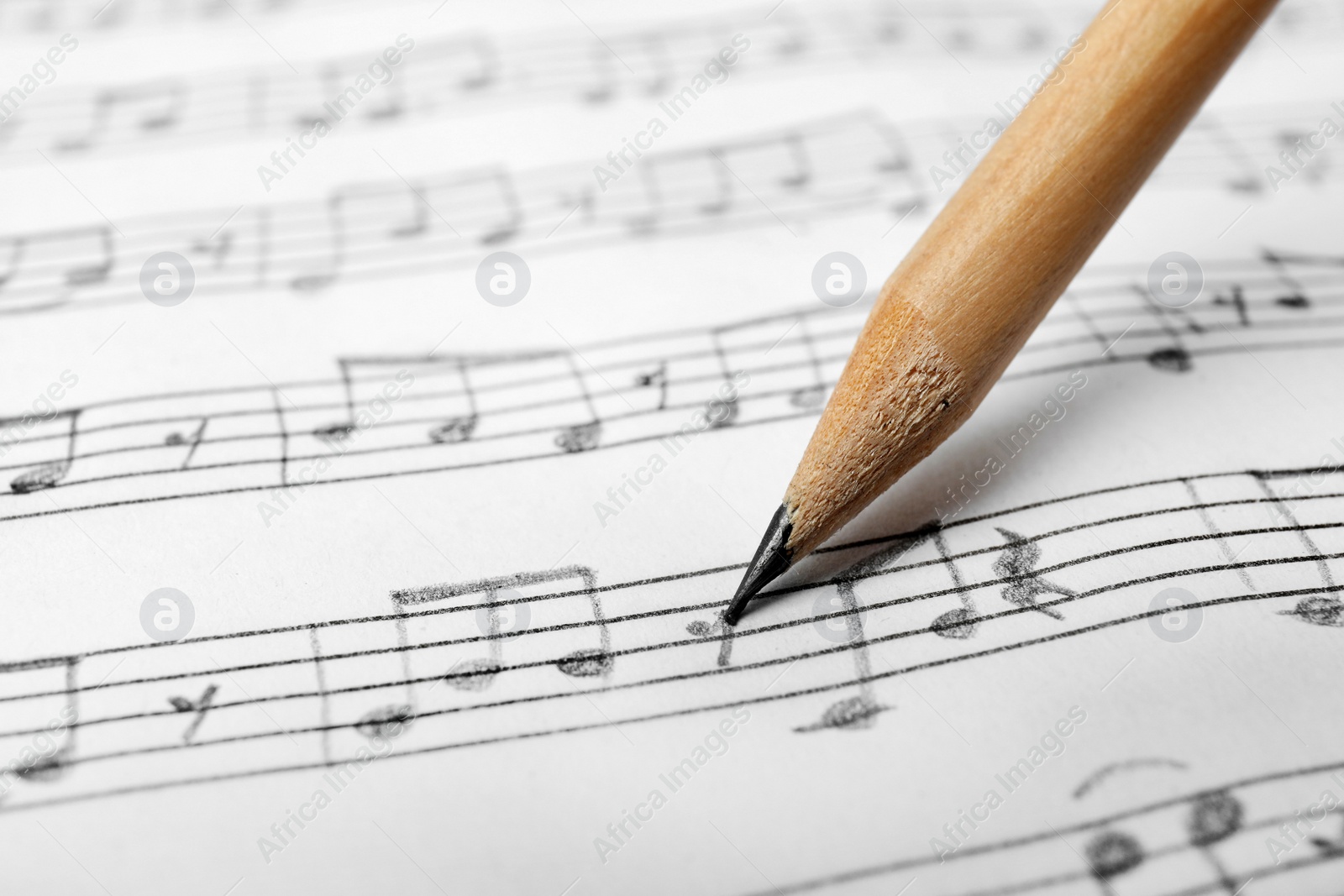 Photo of Sheet with music notes and pencil as background, closeup