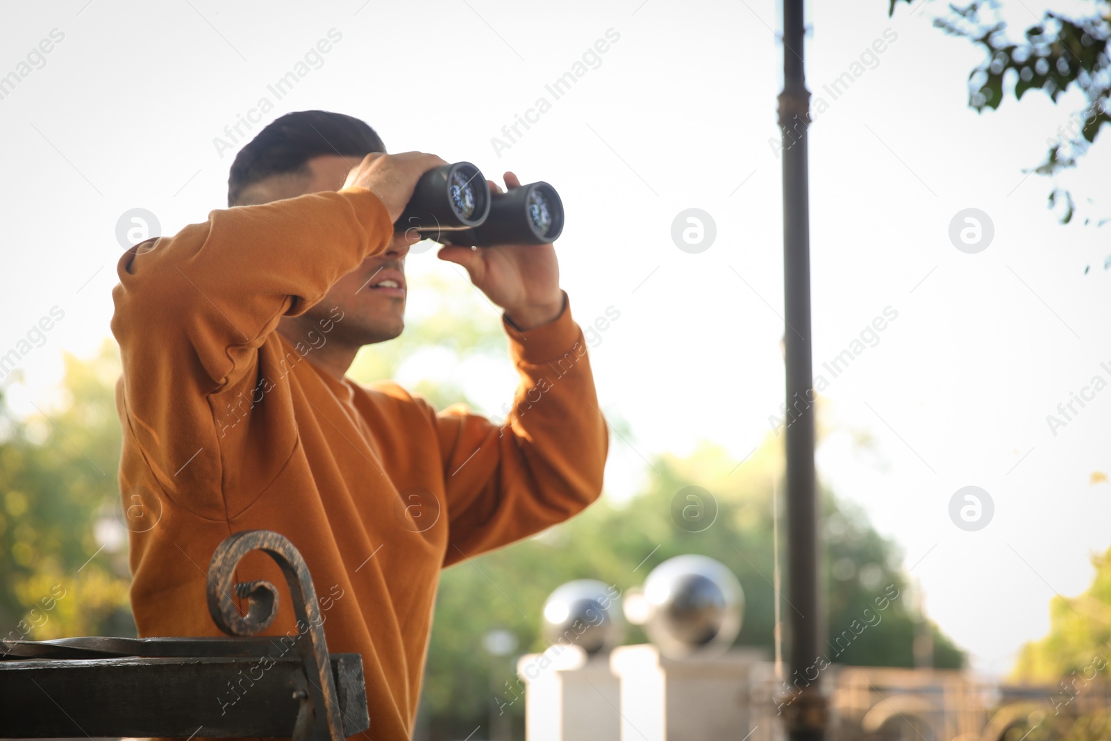 Photo of Jealous man with binoculars spying on ex girlfriend in park