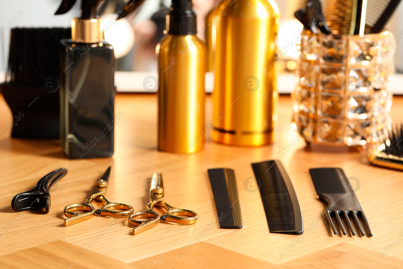 Photo of Hairdresser tools. Different scissors and combs on wooden table, closeup