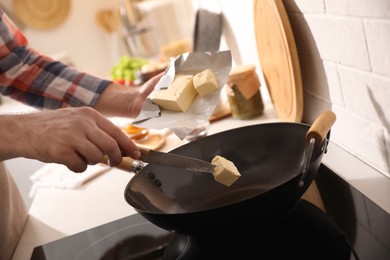 Photo of Man putting butter into frying pan, closeup