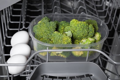 Photo of Cooking raw broccoli and eggs in modern dishwasher, closeup