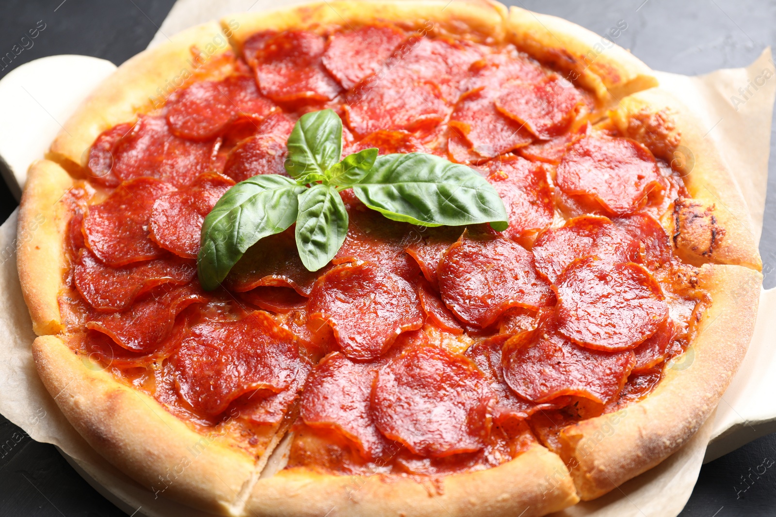 Photo of Tasty pepperoni pizza on black table, closeup