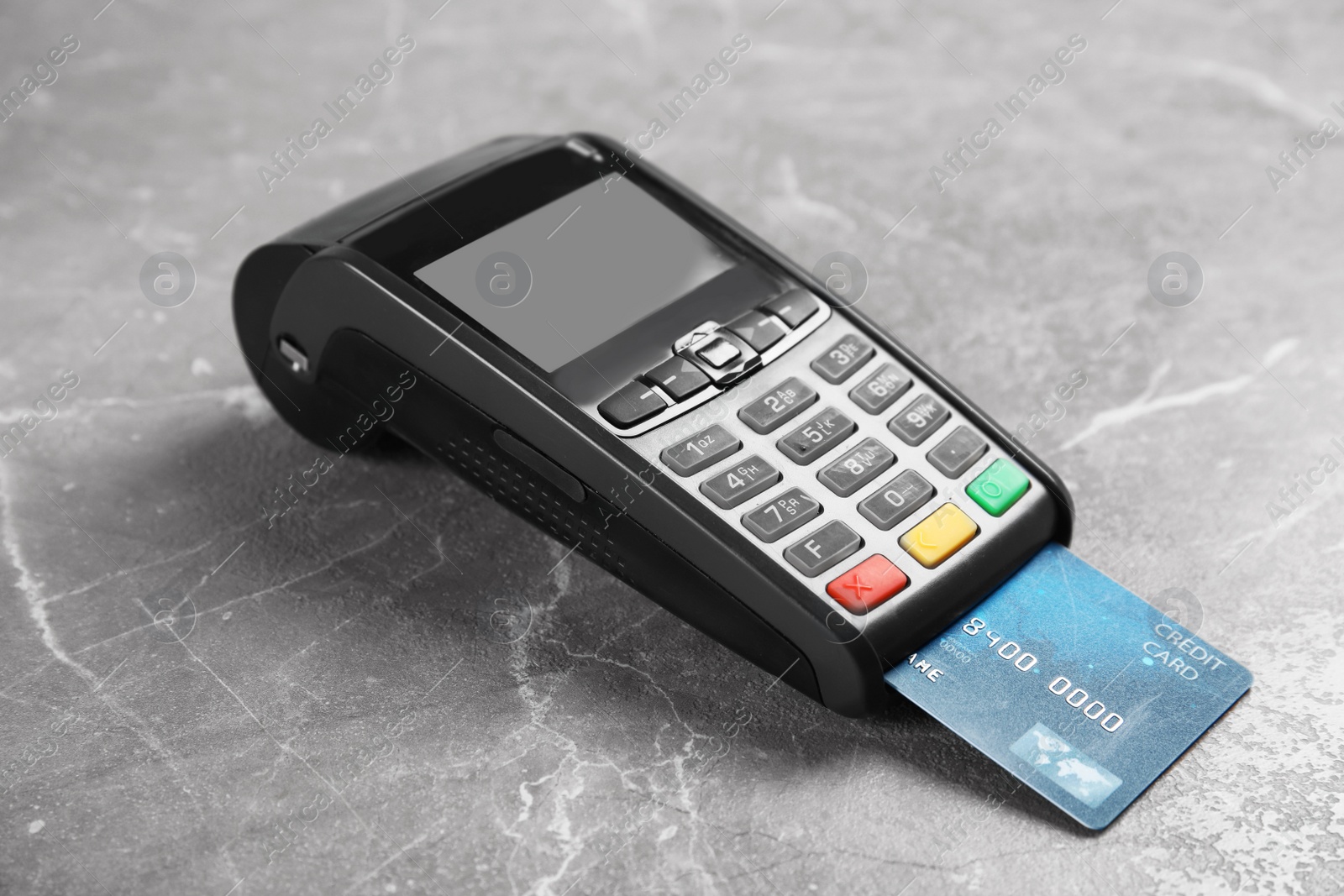 Photo of Modern payment terminal with credit card on grey background