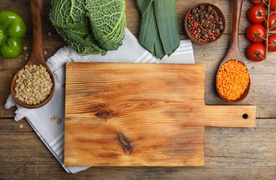 Photo of Board and different ingredients on wooden table, flat lay with space for text. Cooking classes