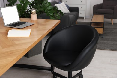 Photo of Comfortable office chair near desk in modern workplace