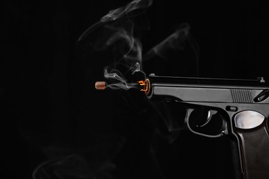 Image of Bullet flying from gun on black background