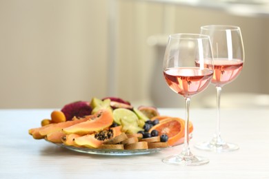 Delicious exotic fruits and wine on white table