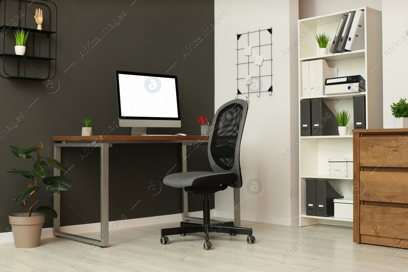 Photo of Stylish office interior with comfortable chair, desk and computer