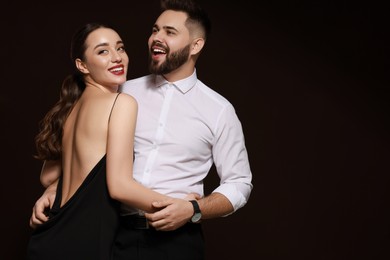 Photo of Handsome bearded man with sexy lady on dark background. Space for text
