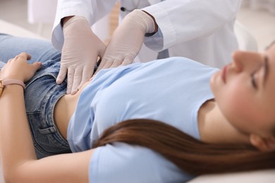 Photo of Gastroenterologist examining patient with stomach pain in clinic, closeup