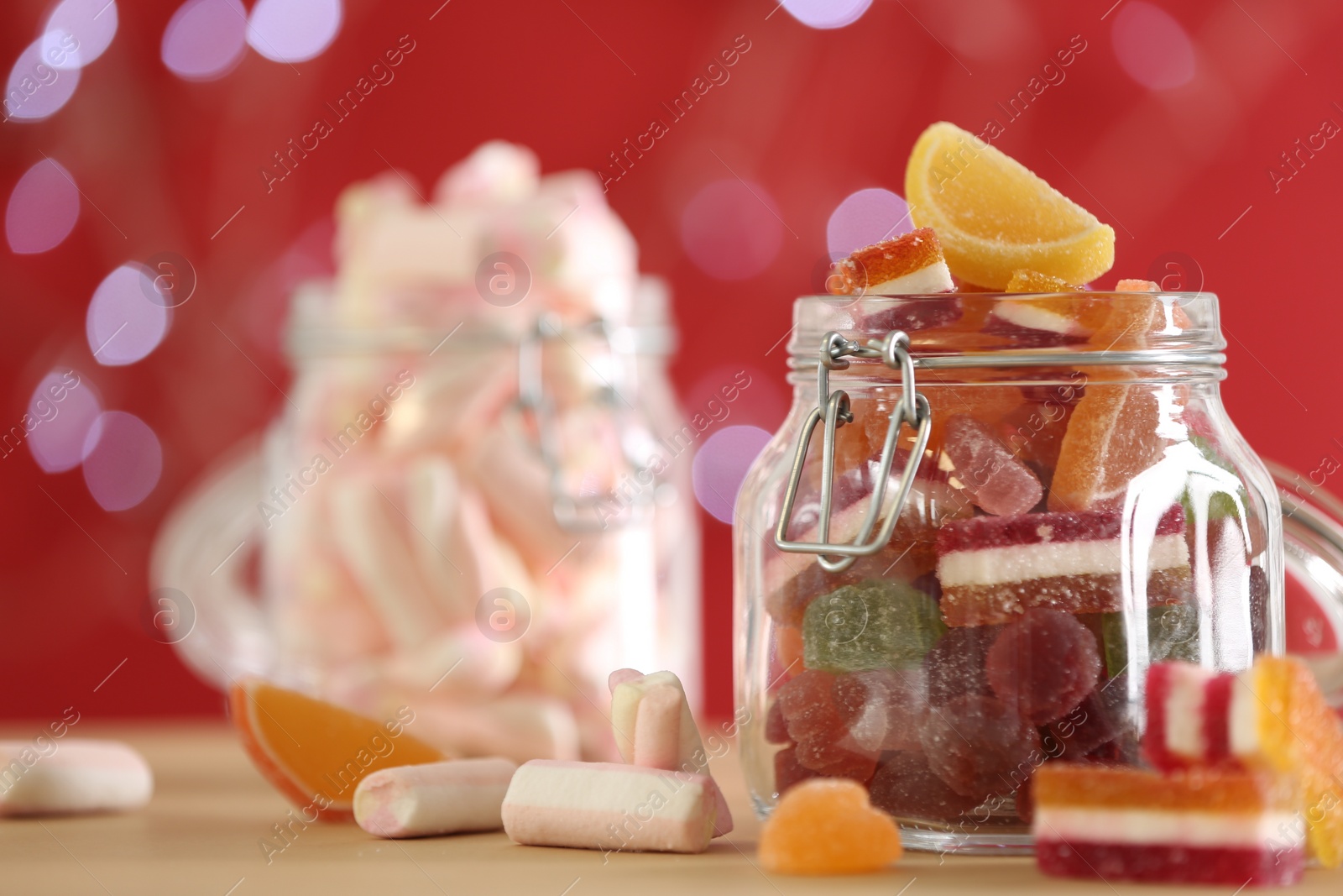 Photo of Delicious jelly candies on table against blurred background, closeup