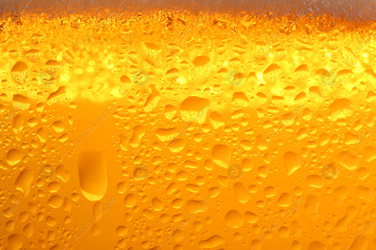 Photo of Glass of tasty cold beer with condensation drops as background, closeup