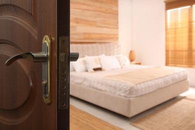 Wooden door open into modern hotel room, closeup