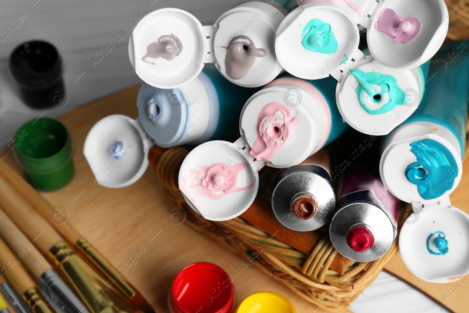 Photo of Colorful paints and brushes on table, closeup