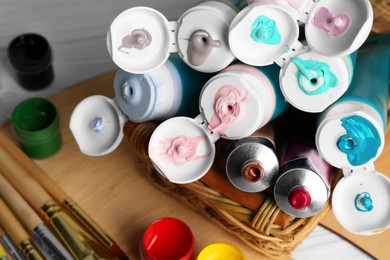 Colorful paints and brushes on table, closeup