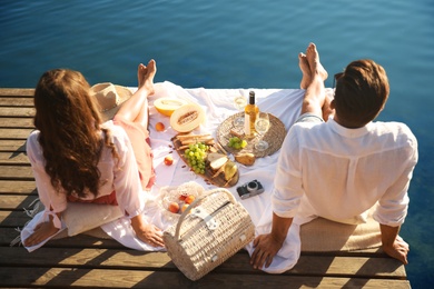 Photo of Happy couple spending time on pier at picnic