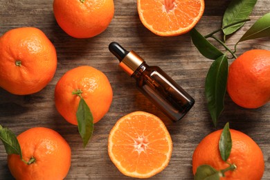 Flat lay composition with tangerine essential oil on wooden table