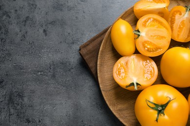 Photo of Fresh ripe yellow tomatoes on grey table, top view. Space for text