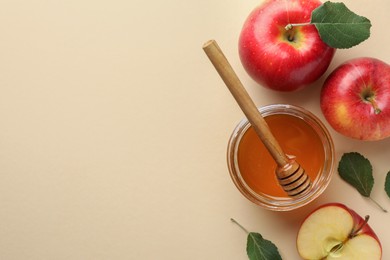 Photo of Delicious apples, jar of honey, leaves and dipper on beige background, flat lay. Space for text