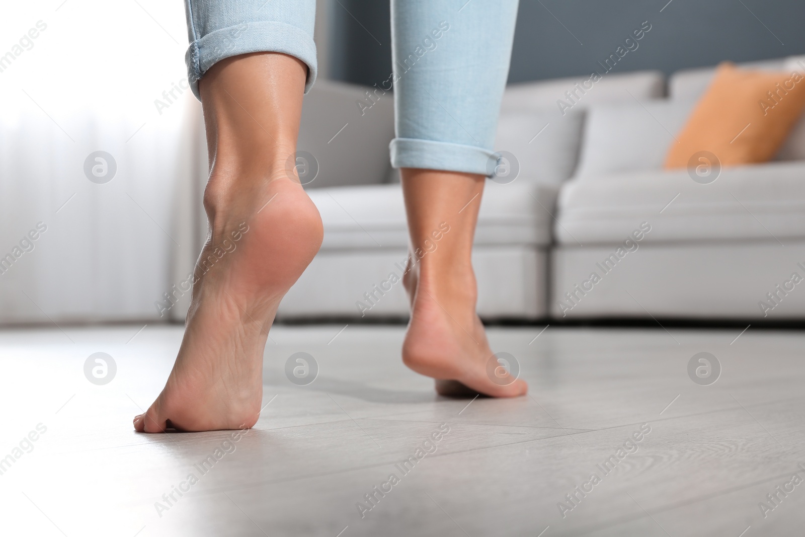 Photo of Woman walking barefoot at home, closeup. Floor heating concept