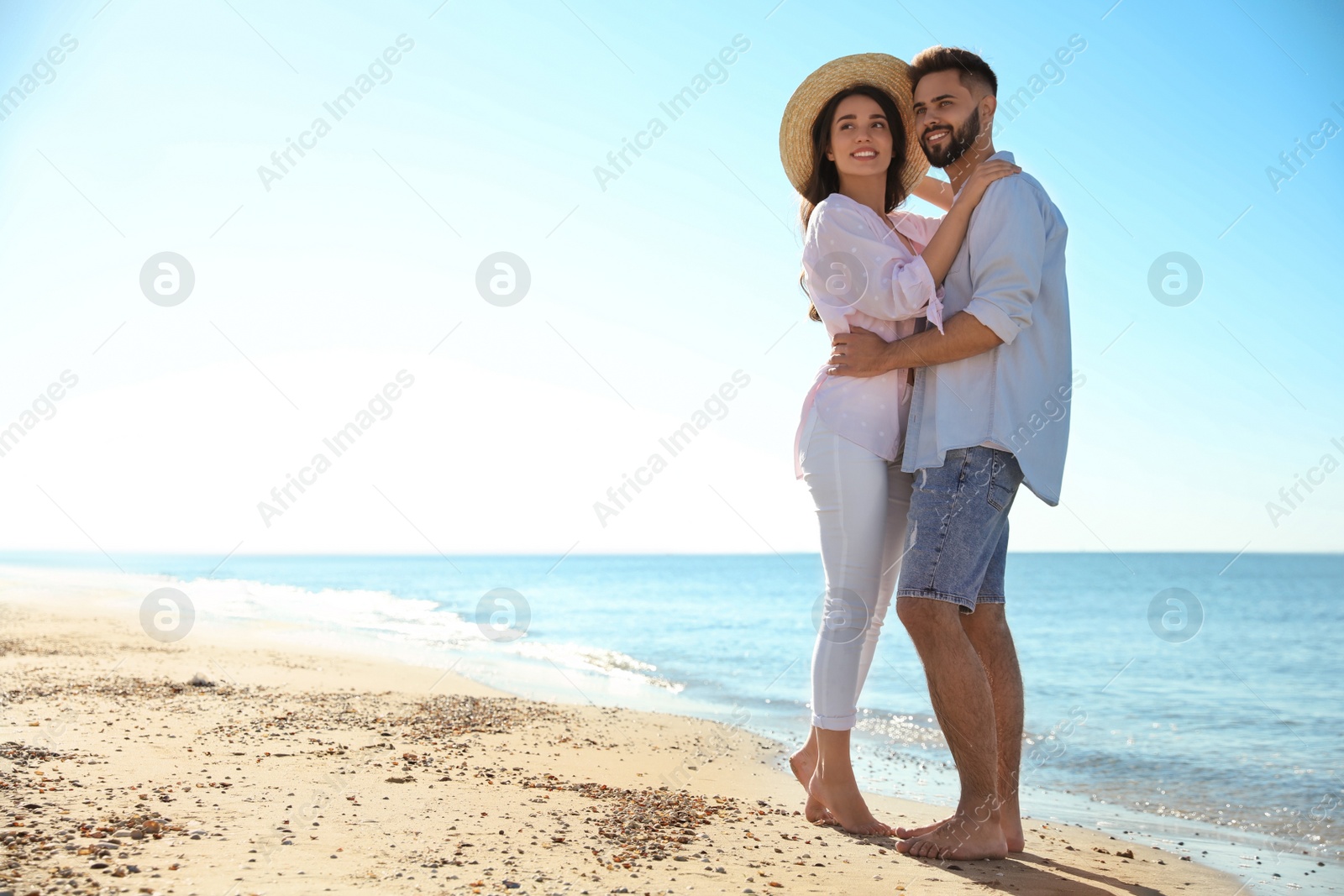 Photo of Happy young couple on beach near sea. Honeymoon trip