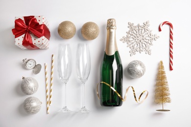 Photo of Creative flat lay composition with bottle of champagne and party accessories on white background