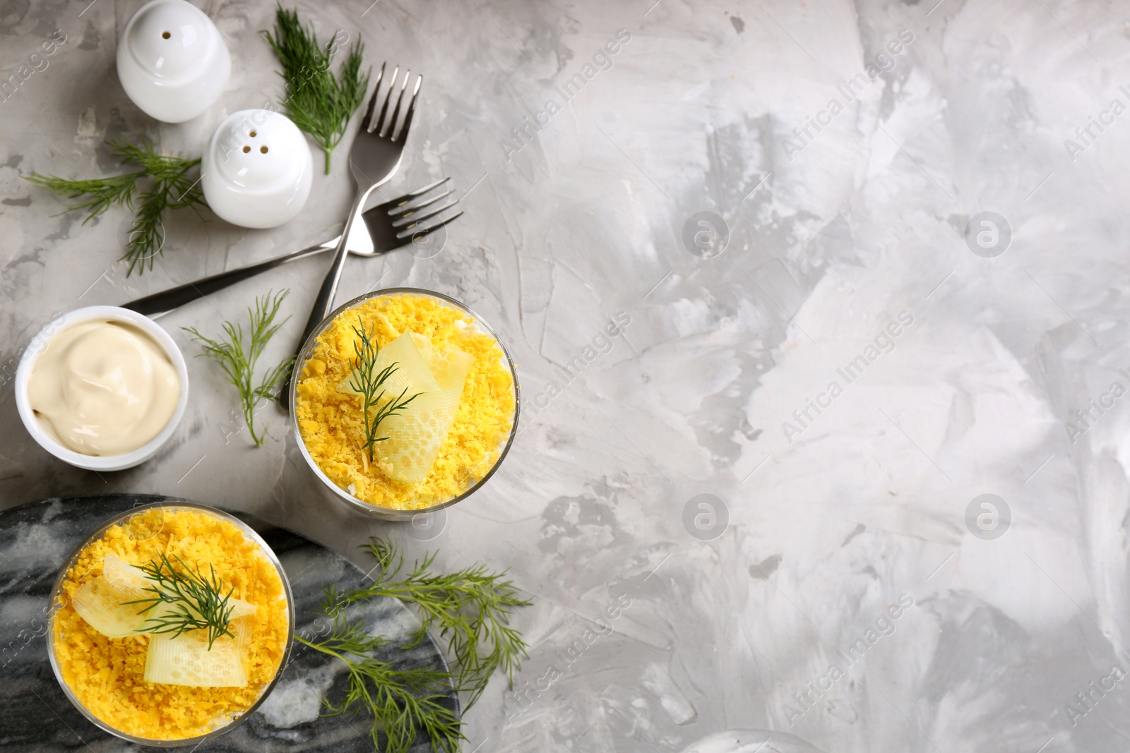 Photo of Flat lay composition with traditional russian salad Mimosa on light grey table, space for text