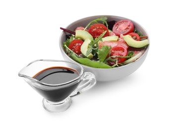 Photo of Tasty soy sauce and bowl with salad isolated on white