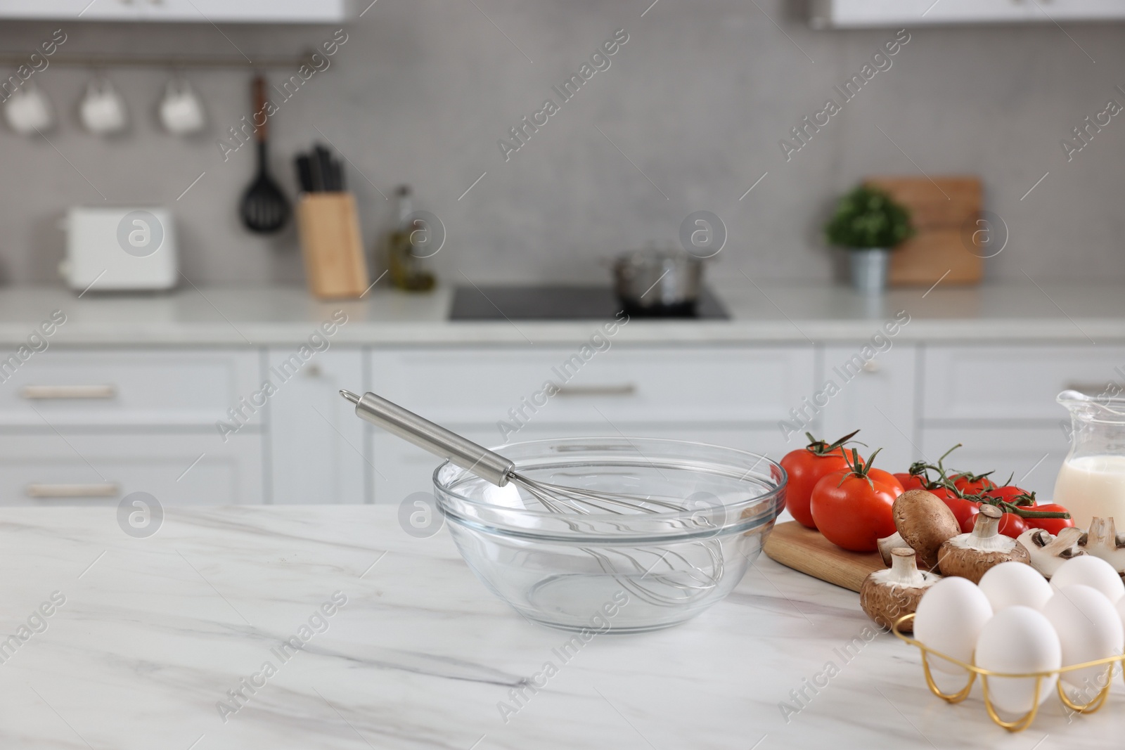 Photo of Whisk, bowl, and different ingredients on white marble table indoors, space for text