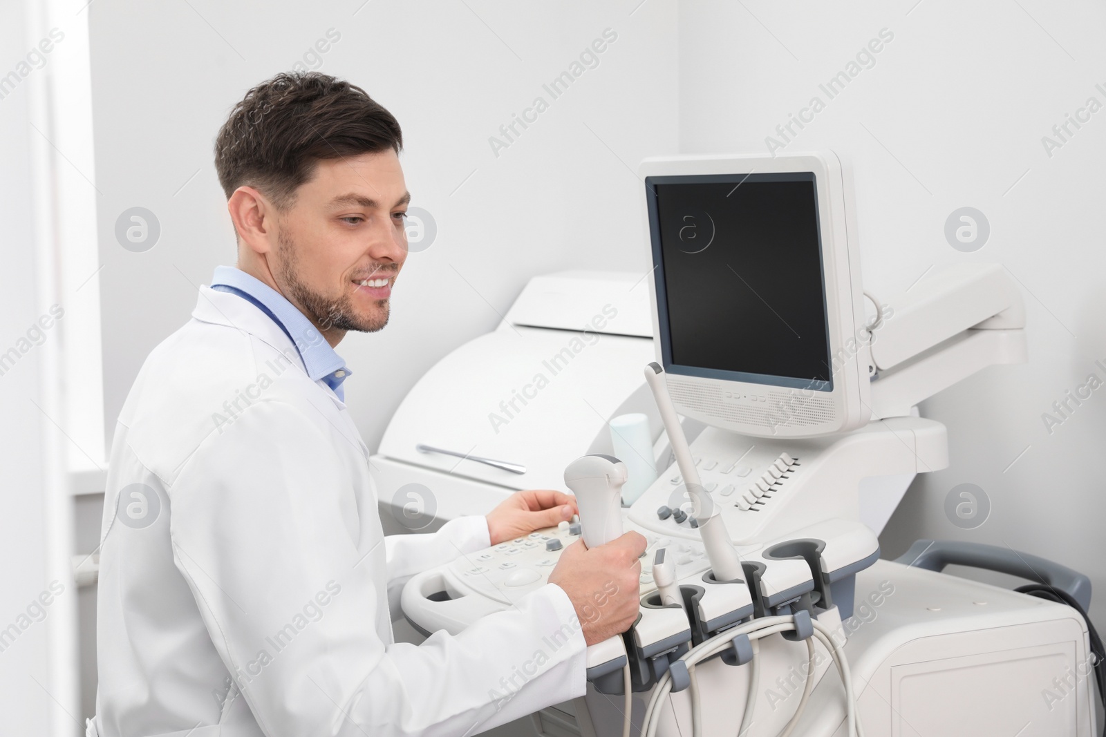 Photo of Sonographer operating modern ultrasound machine in clinic