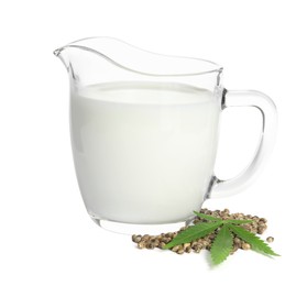 Photo of Glass jug with fresh hemp milk, seeds and leaf on white background