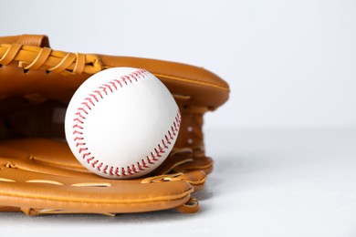 Photo of Catcher's mitt and baseball ball on white background, closeup with space for text. Sports game