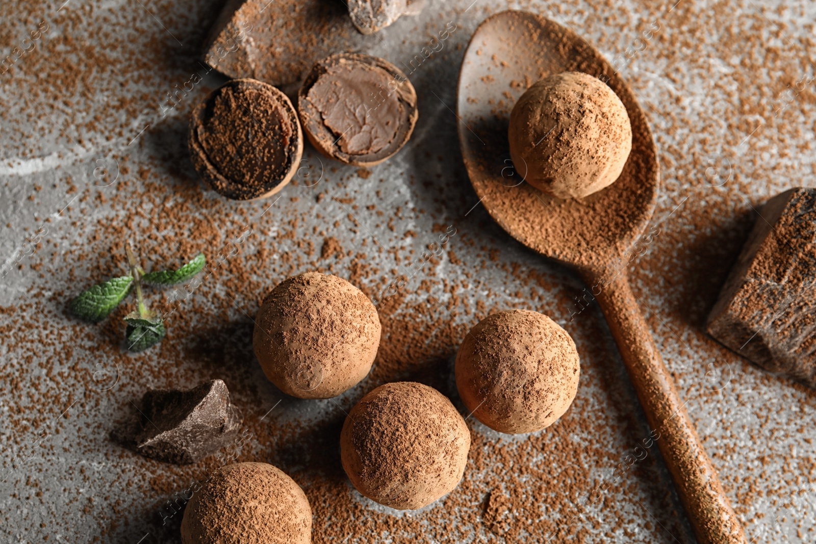 Photo of Flat lay composition with spoon and chocolate truffles on grey background