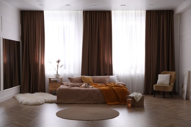 Bed with brown linens in stylish room interior