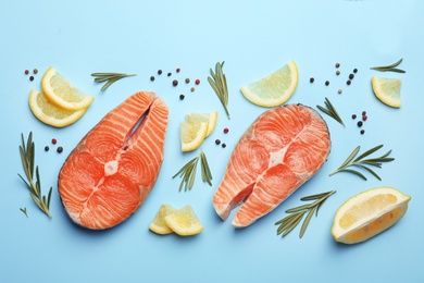 Flat lay composition with salmon steaks on blue background